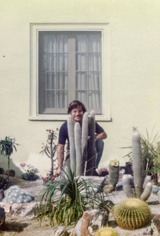 vintage photo of co-founder Ken Altman kneeling next to tall cacti